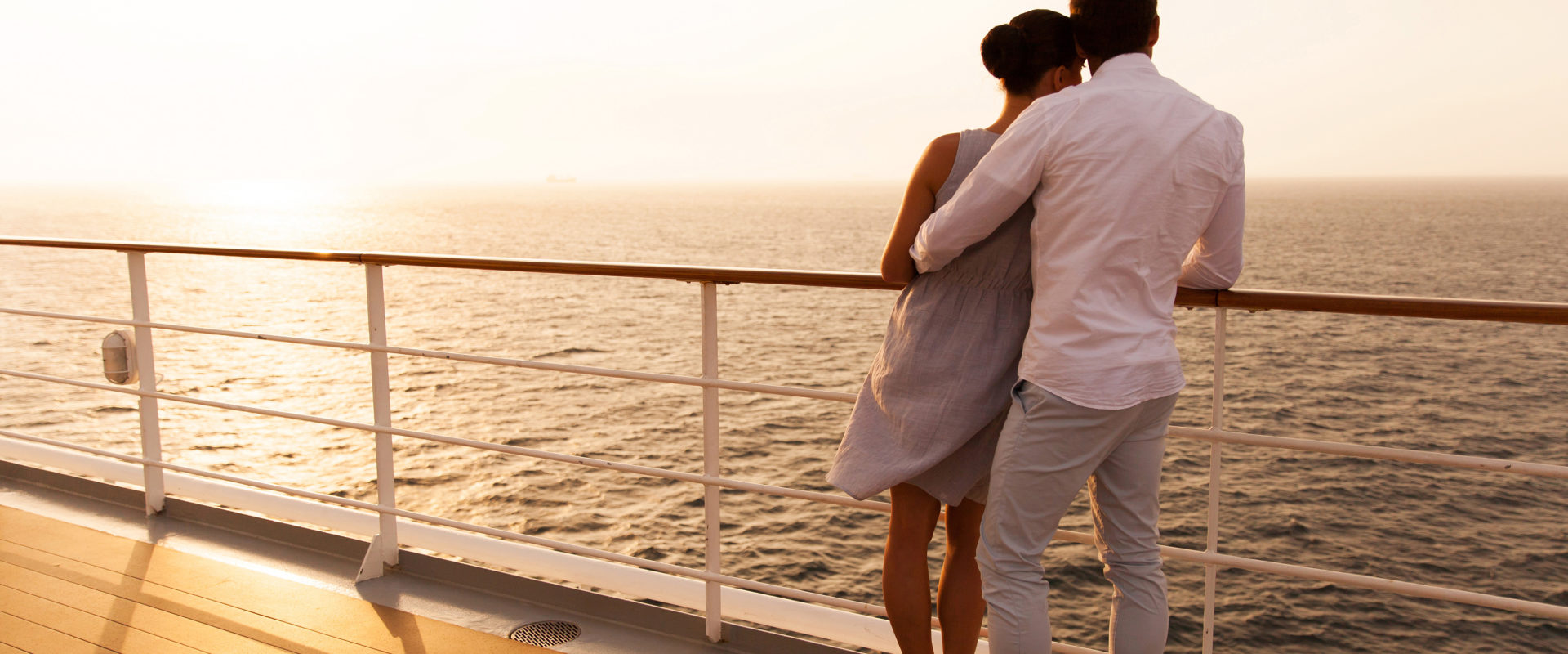 young couple hugging at sunset on cruise ship