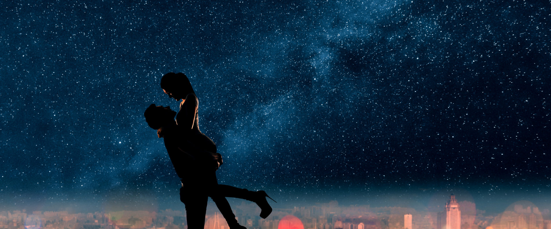 A man hold his girlfriend romantically above the city